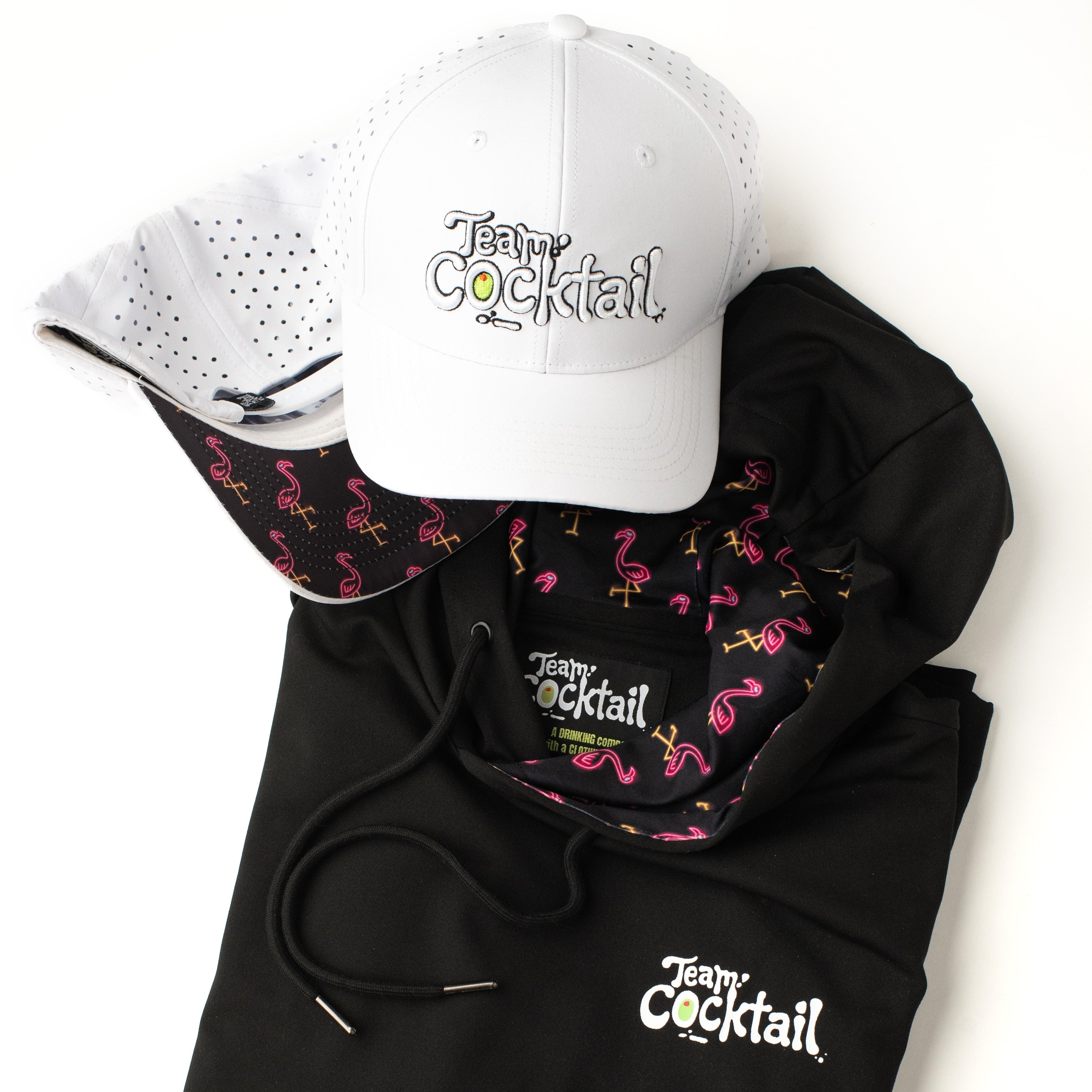 Black hoodie with flamingo pattern and 'Teeny Cocktail' branding, paired with a white cap on a white background.