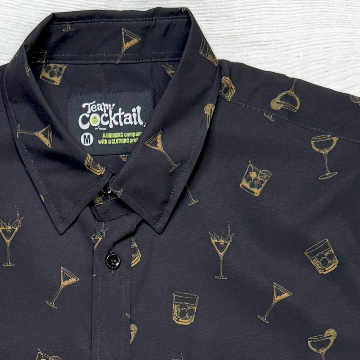 Black shirt with cocktail pattern and 'Team Cocktail' label on a white background