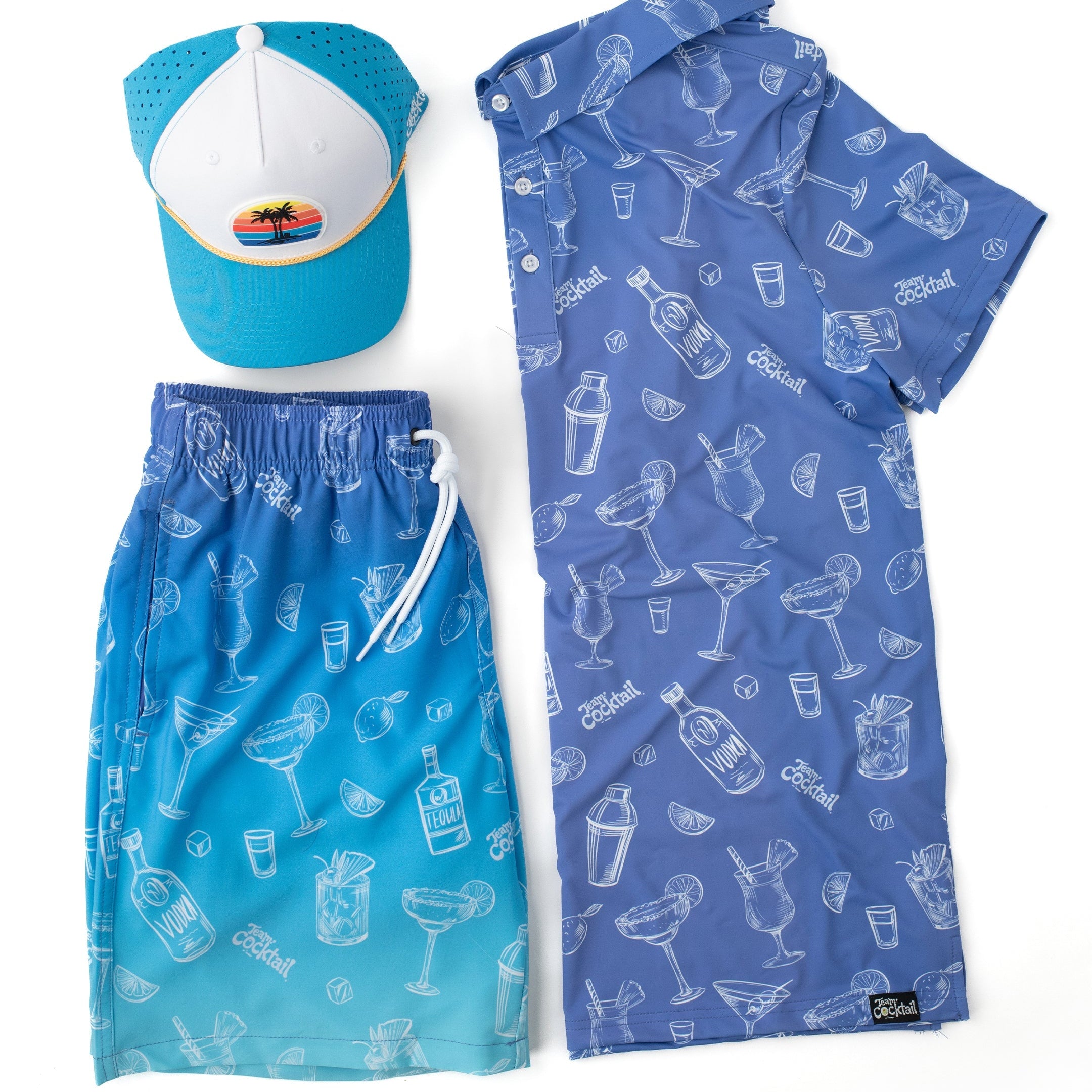Blue swim set with cap, towel, and shorts featuring cocktail patterns on a white background