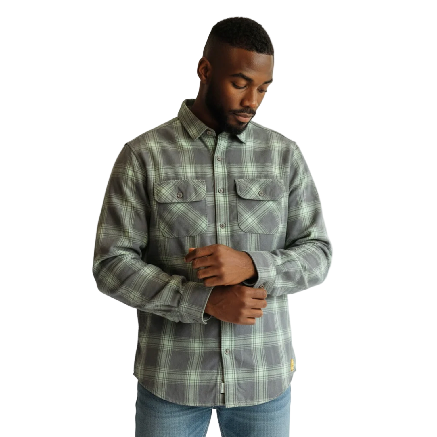 Man wearing a plaid shirt and jeans against a white background