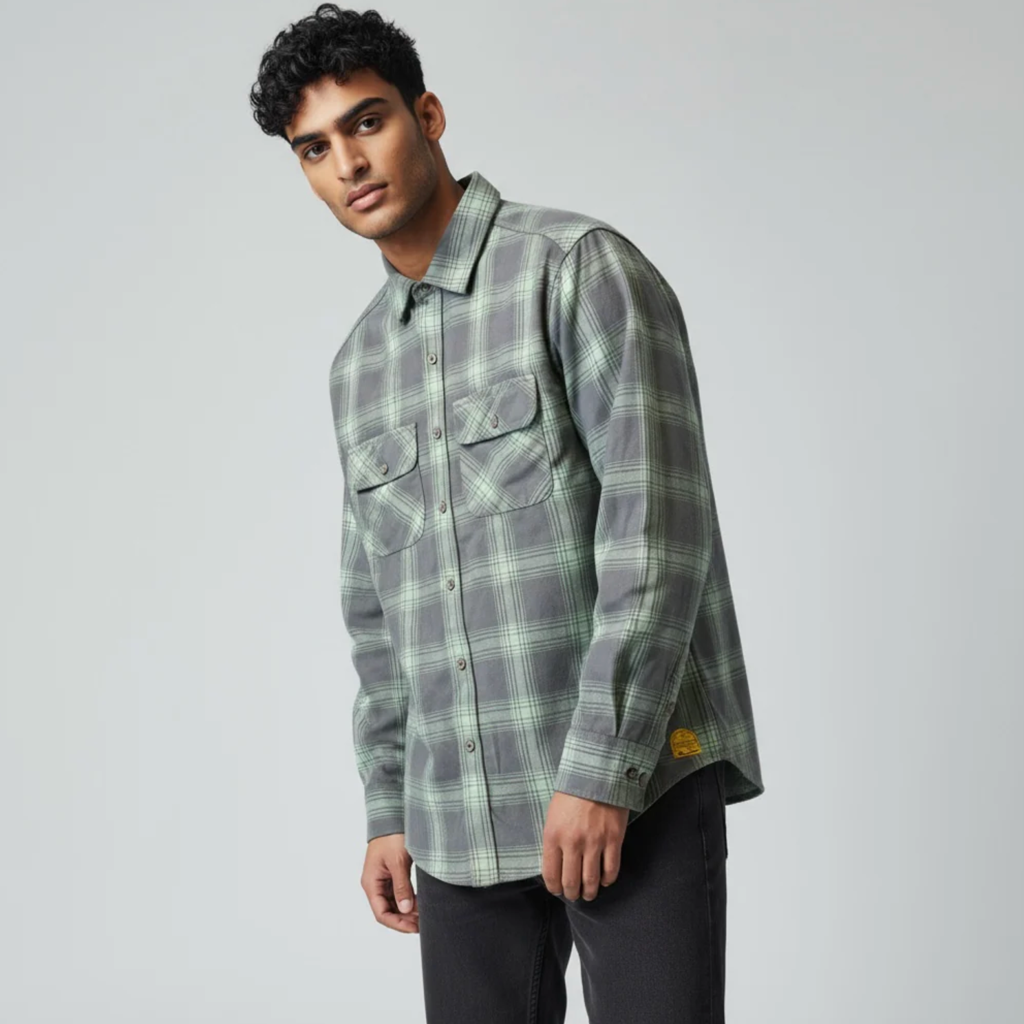 Man wearing a plaid shirt with a gray background