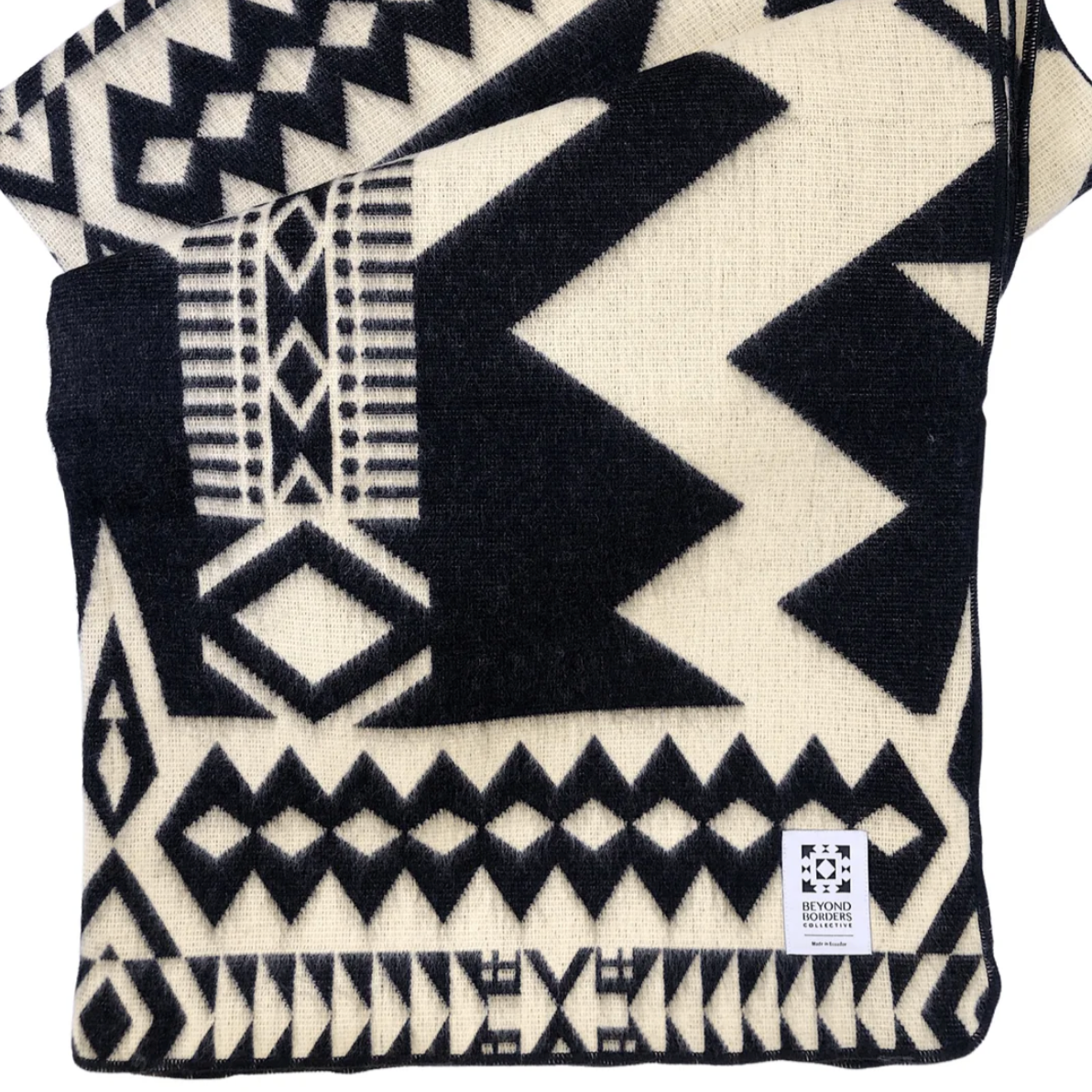 Black and white patterned blanket with a visible brand label on a white background