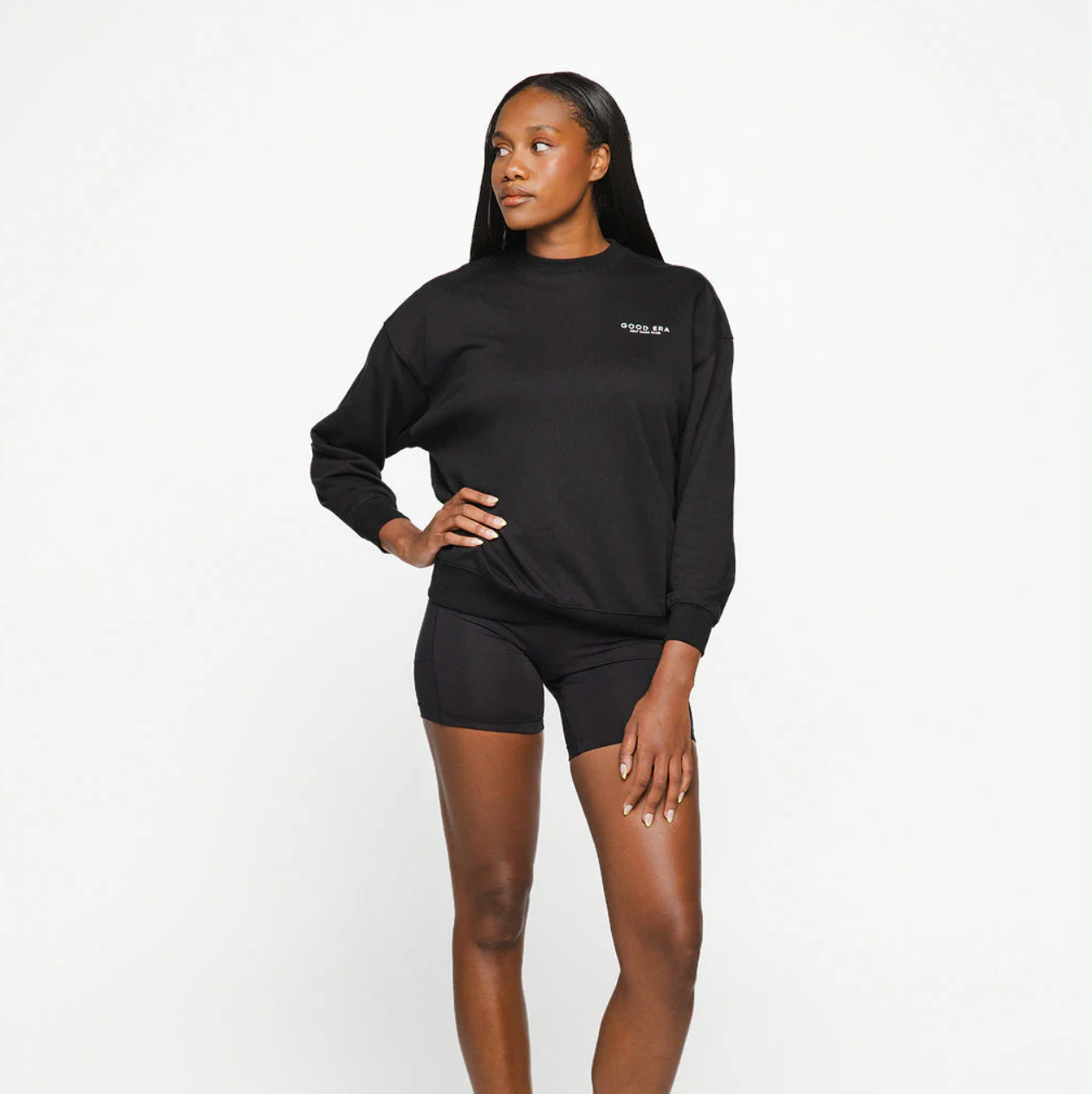 Woman wearing a black sweatshirt and shorts on a white background