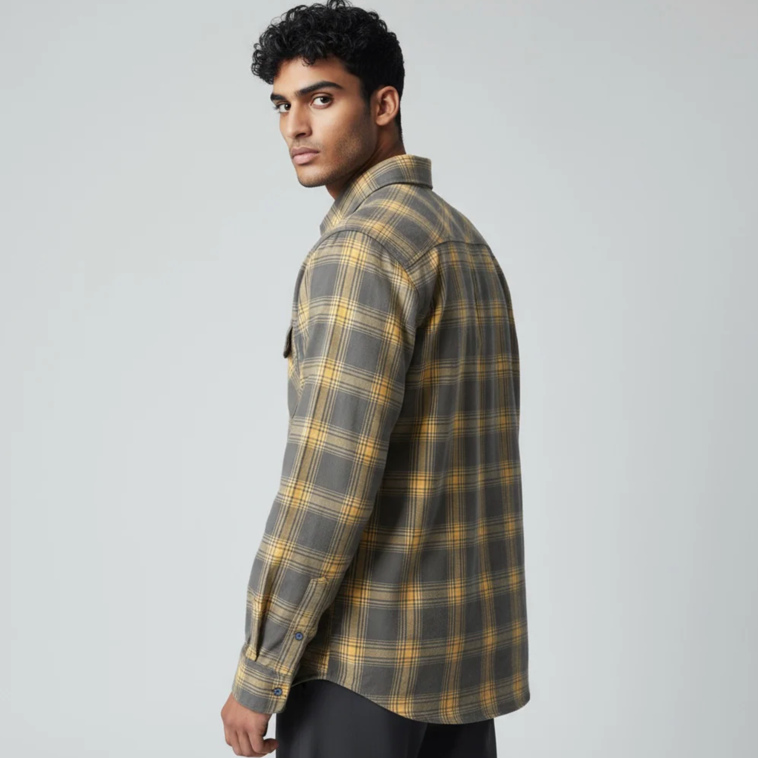 Man wearing a plaid shirt on a gray background