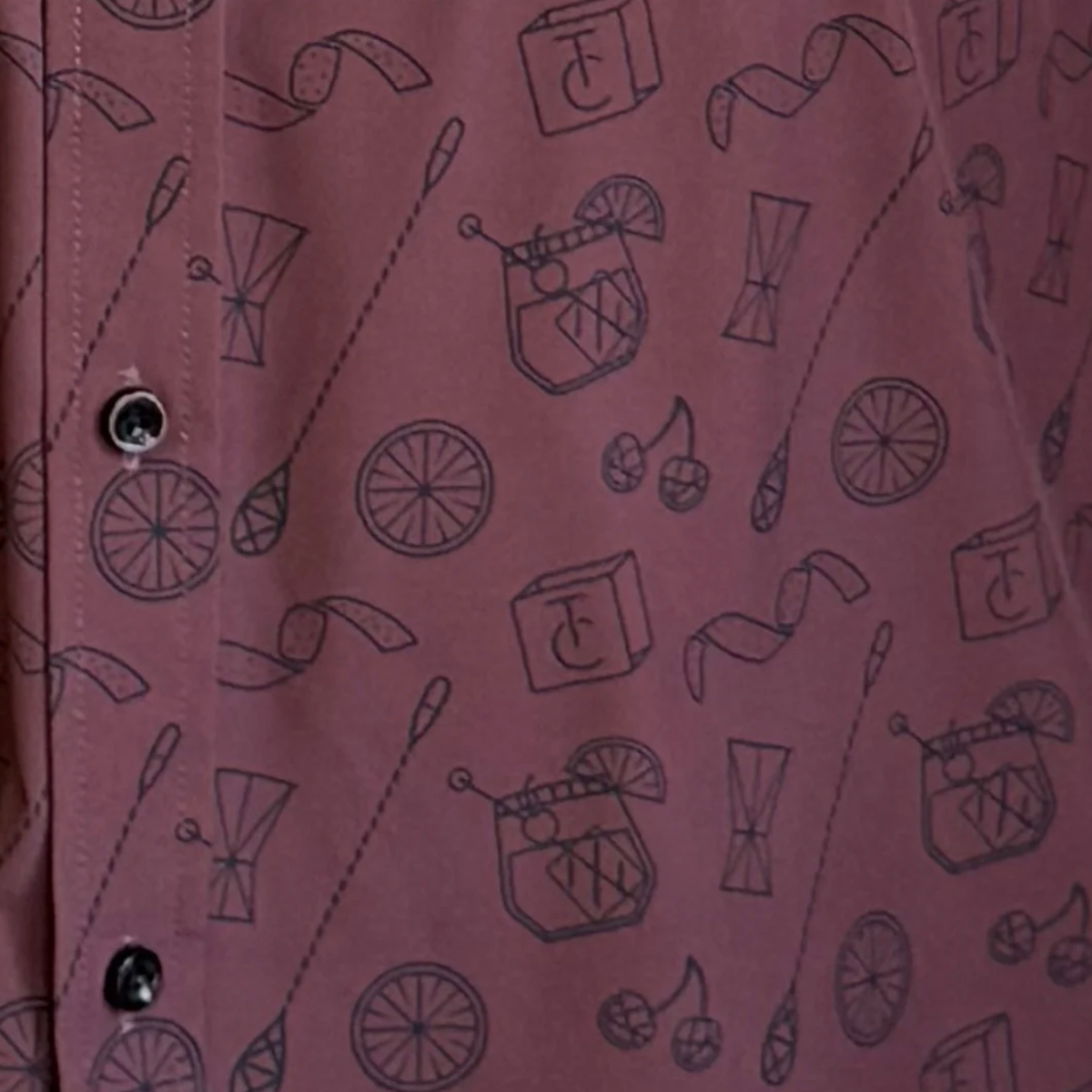 Close-up of a pink fabric with black line art patterns on a pink background