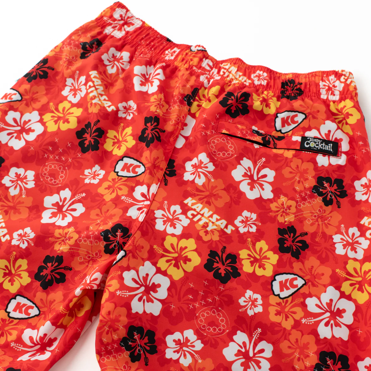 Red floral-patterned shorts with 'KC' and cocktail graphic on a white background