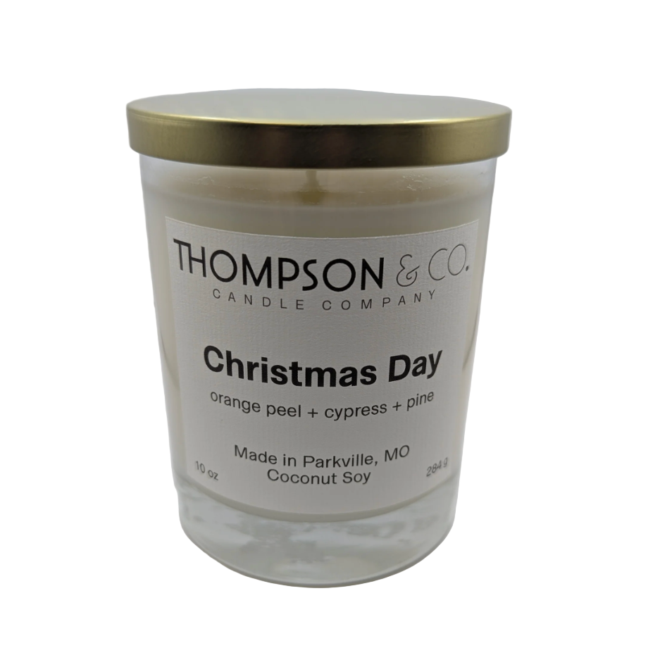 Candle jar with gold lid and 'Thompson & Co' label on a white background