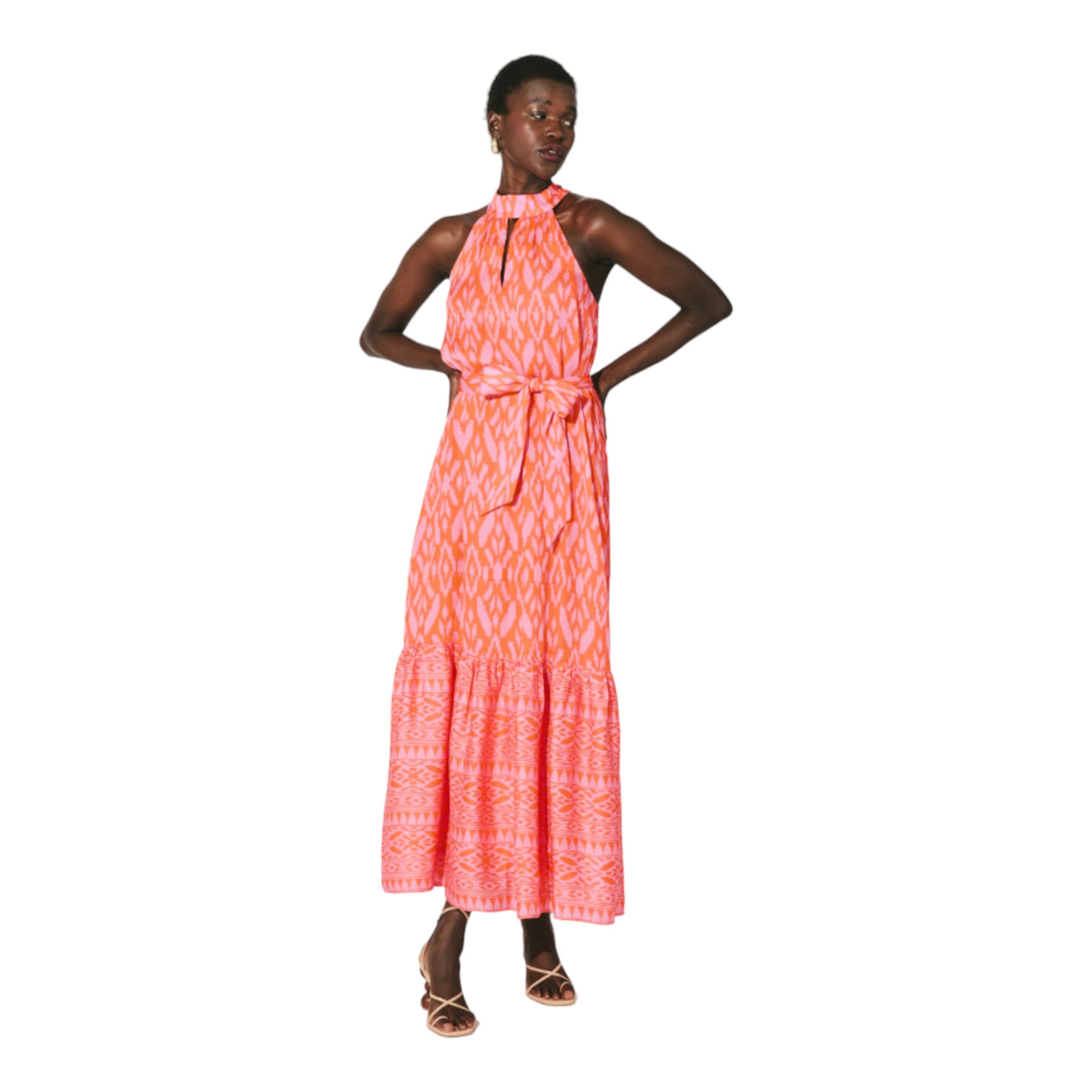 halter style maxi dress with a ruffle hem featuring a pink and orange ikat print with a keyhole cutout detail and tie neck and belted waist