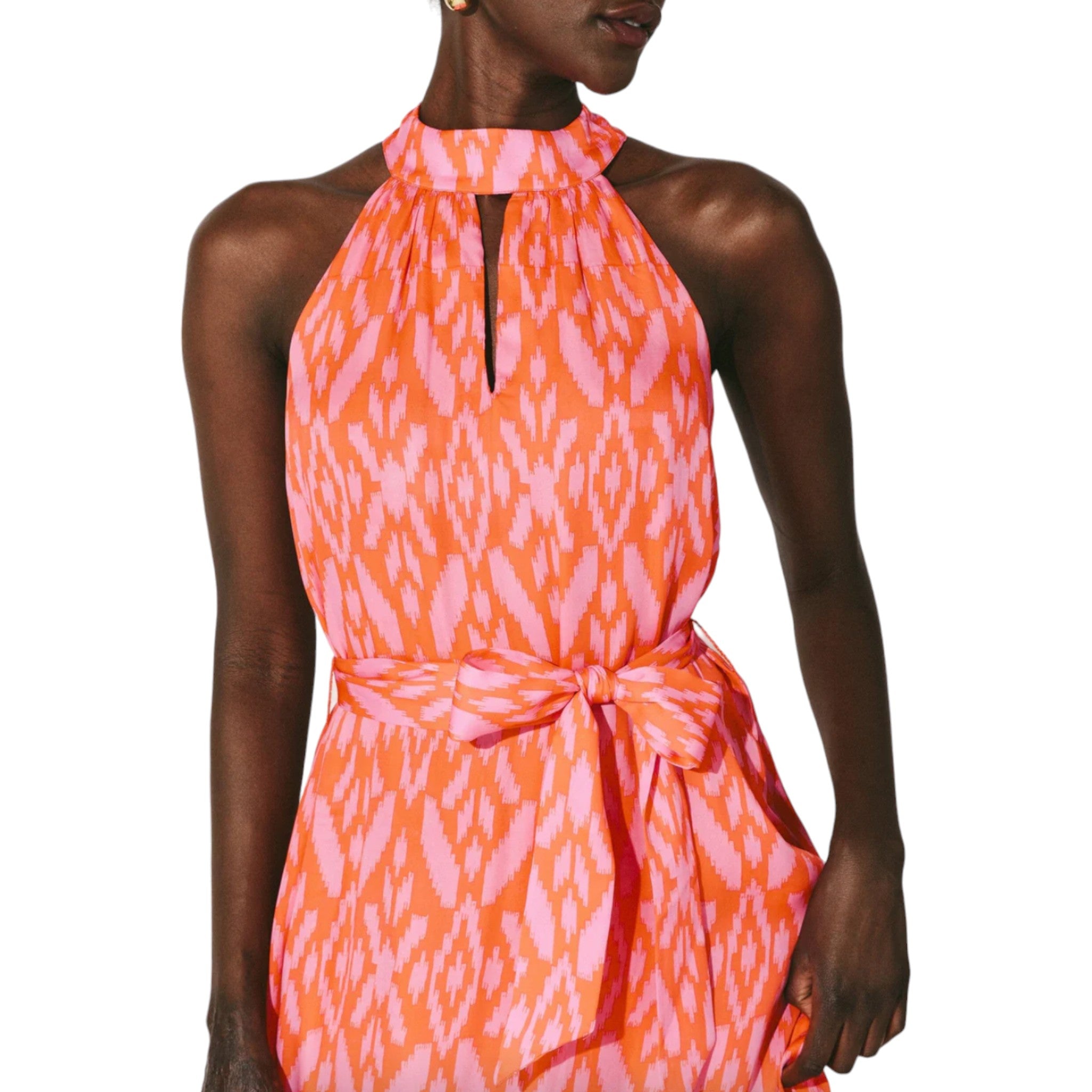 halter style maxi dress with a ruffle hem featuring a pink and orange ikat print with a keyhole cutout detail and tie neck and belted waist