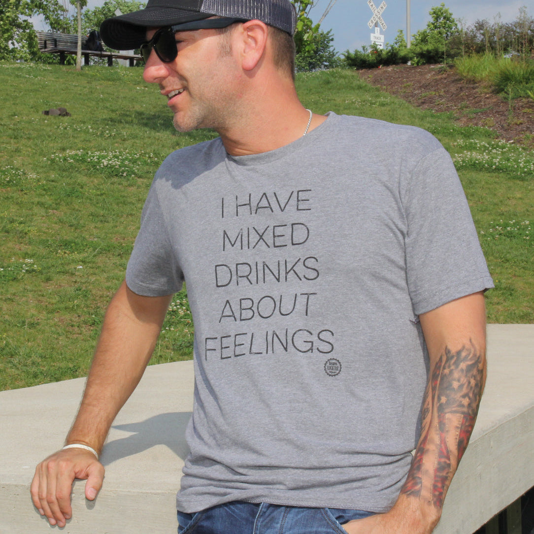 Man wearing a gray t-shirt with text outdoors