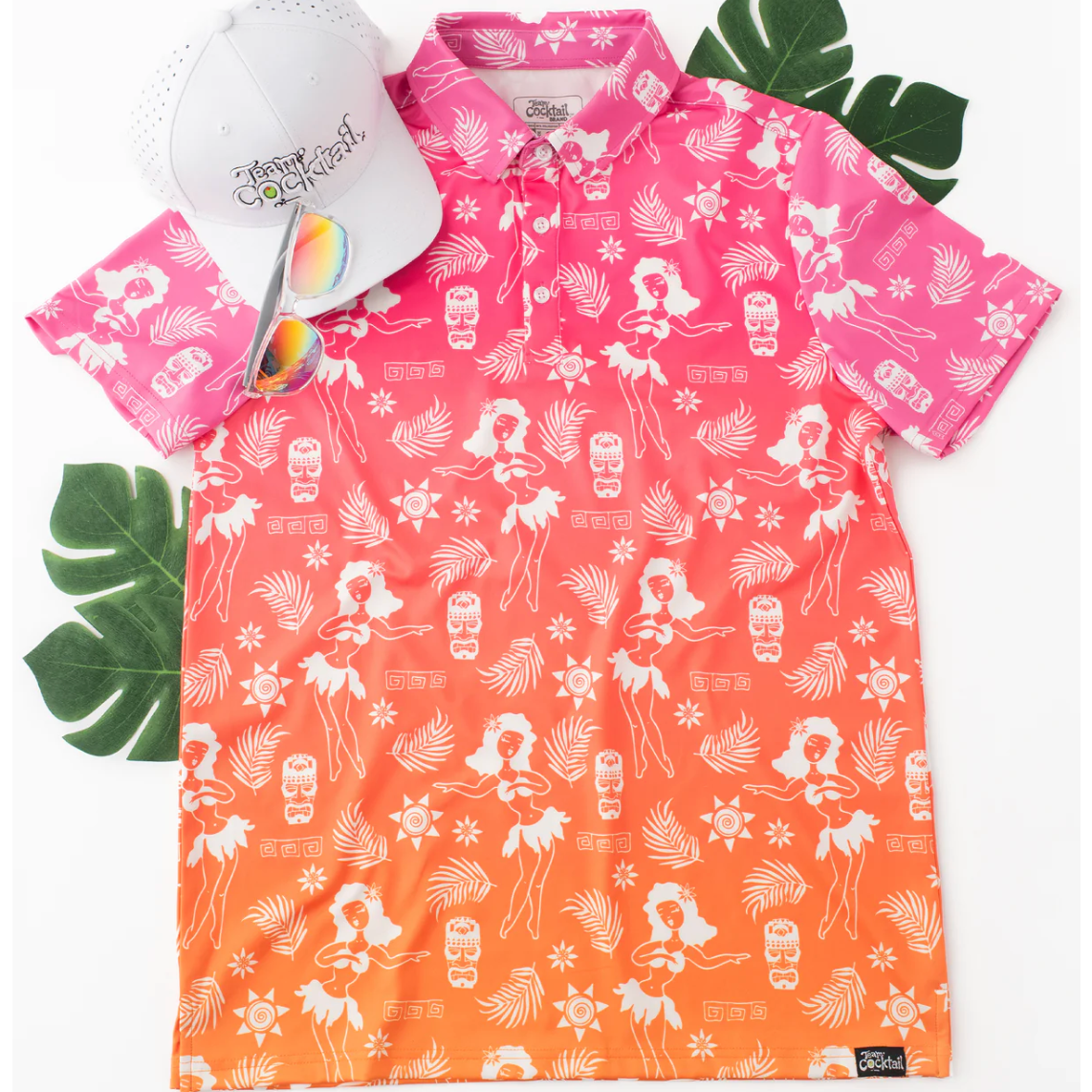 Pink and orange patterned shirt with sunglasses and a hat on a white background