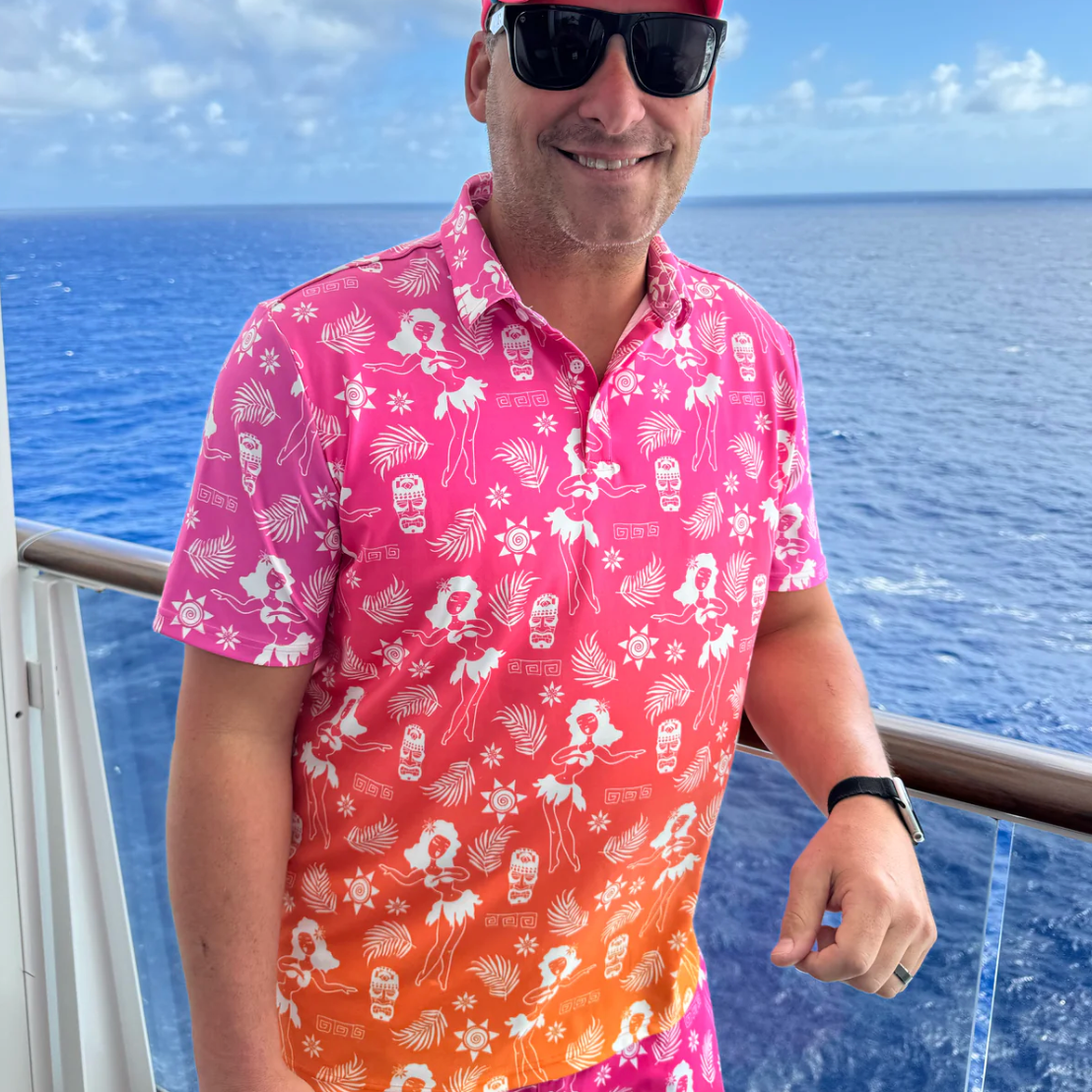Man wearing a colorful shirt with a tropical pattern on a boat deck with ocean view