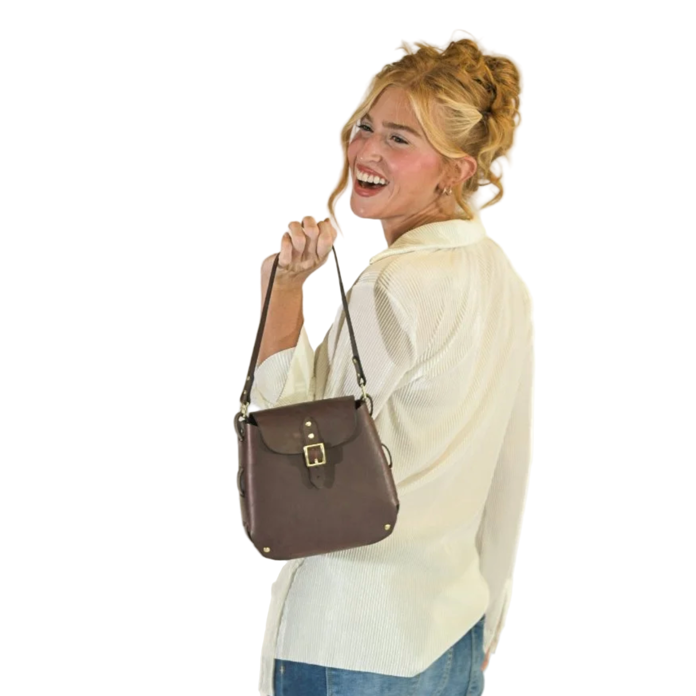 Woman holding a brown leather bag against a plain background