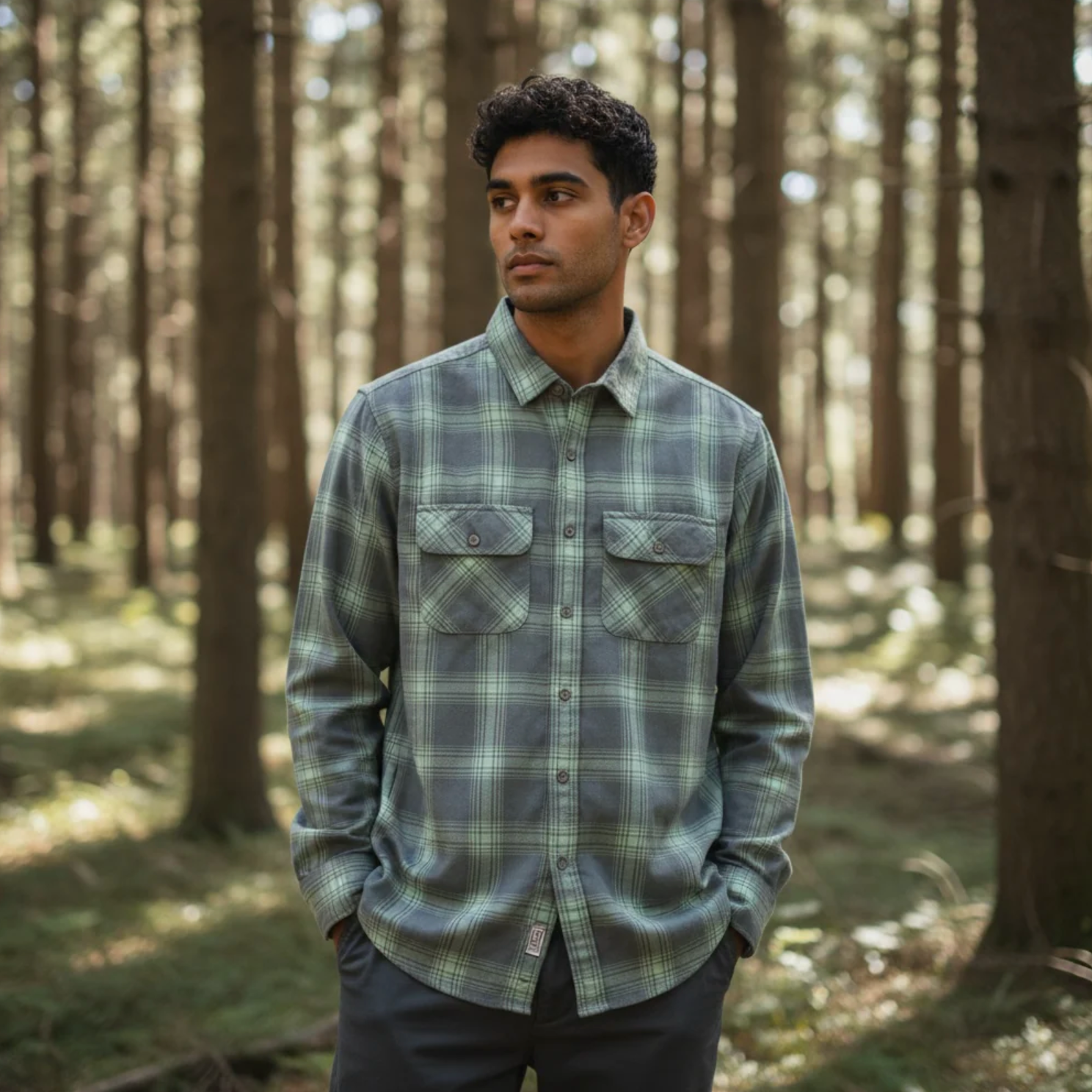Man wearing a plaid shirt in a forest setting
