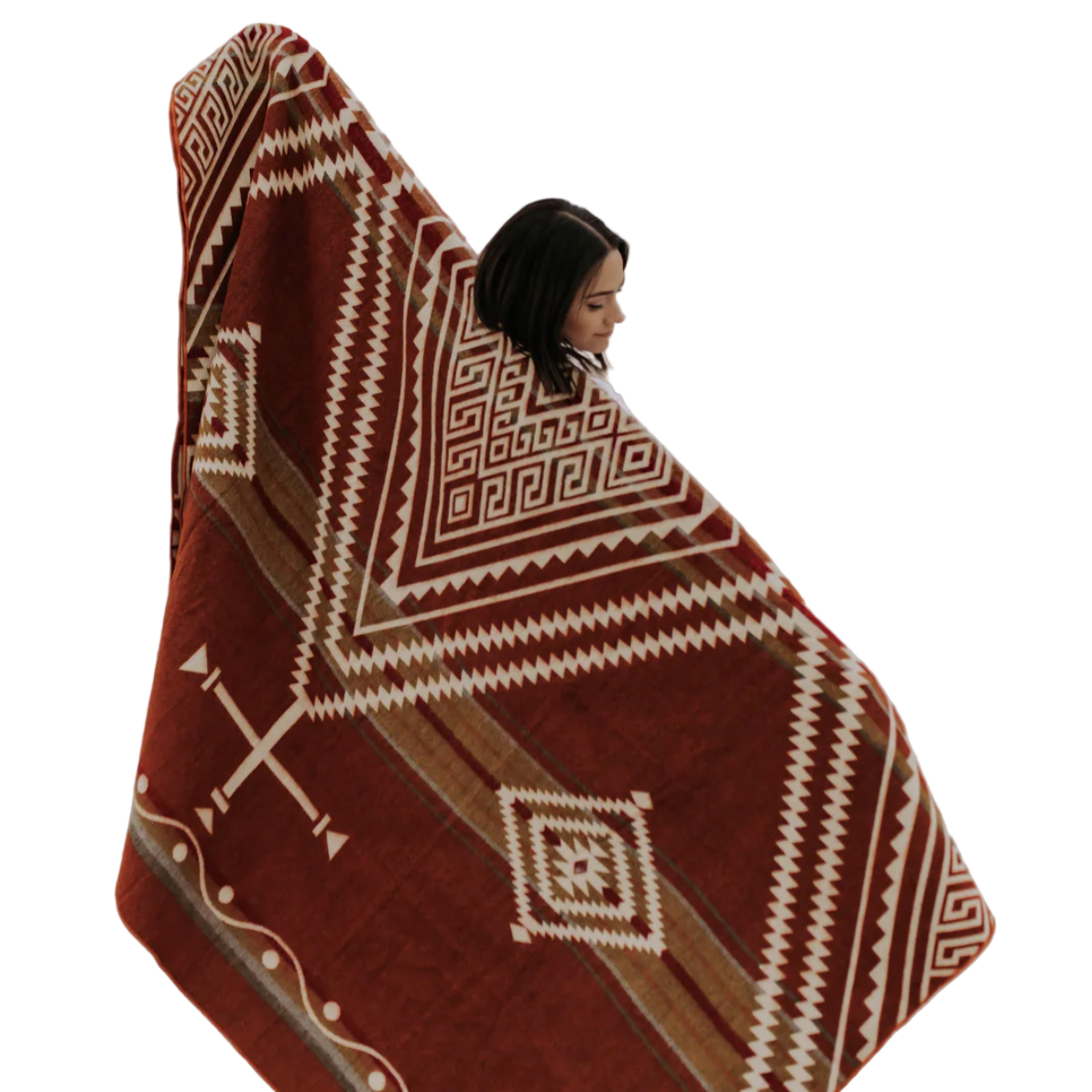 Person wrapped in a patterned blanket in a desert landscape with wind turbines.