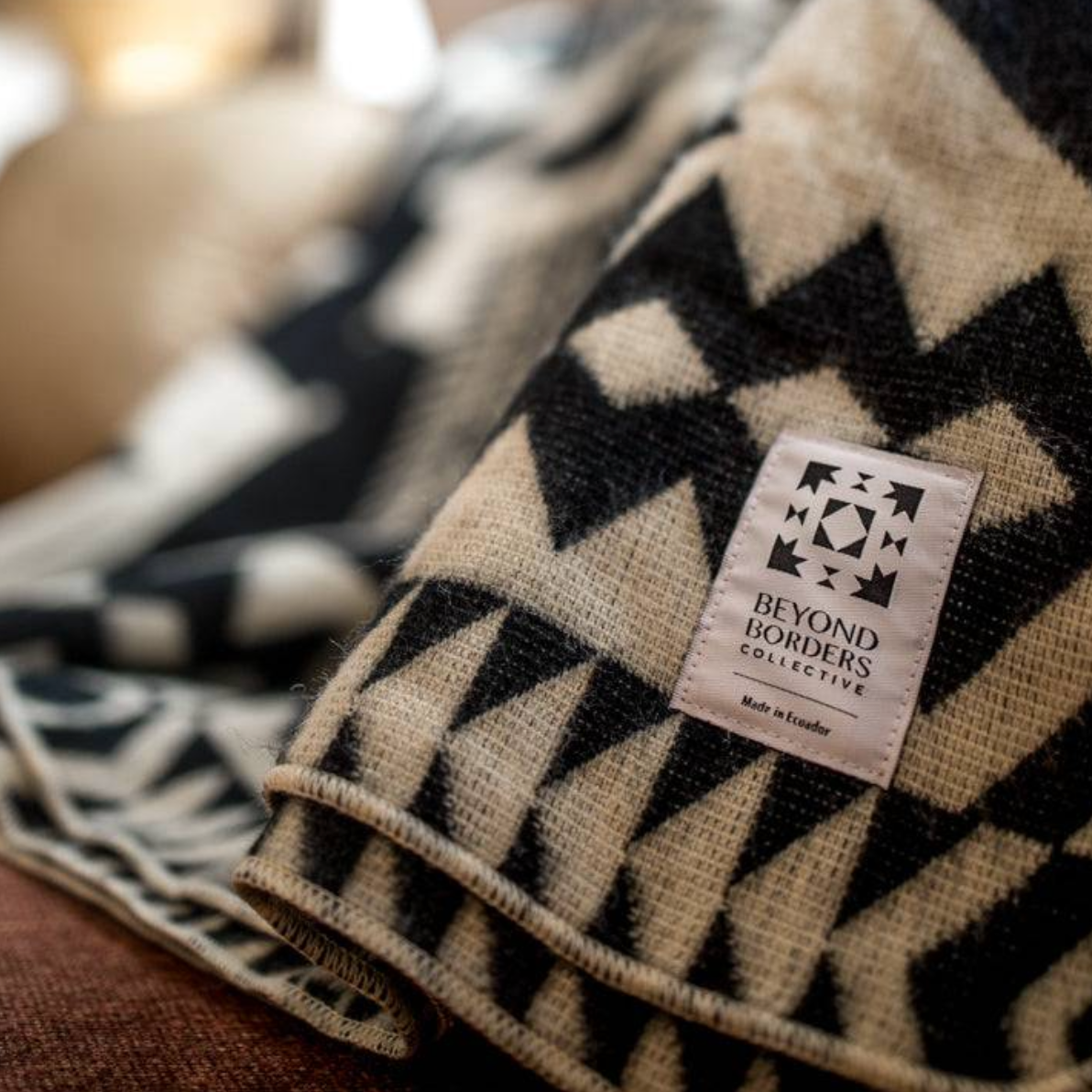 Patterned blanket with 'Beyond Borders Collective' label on a blurred background