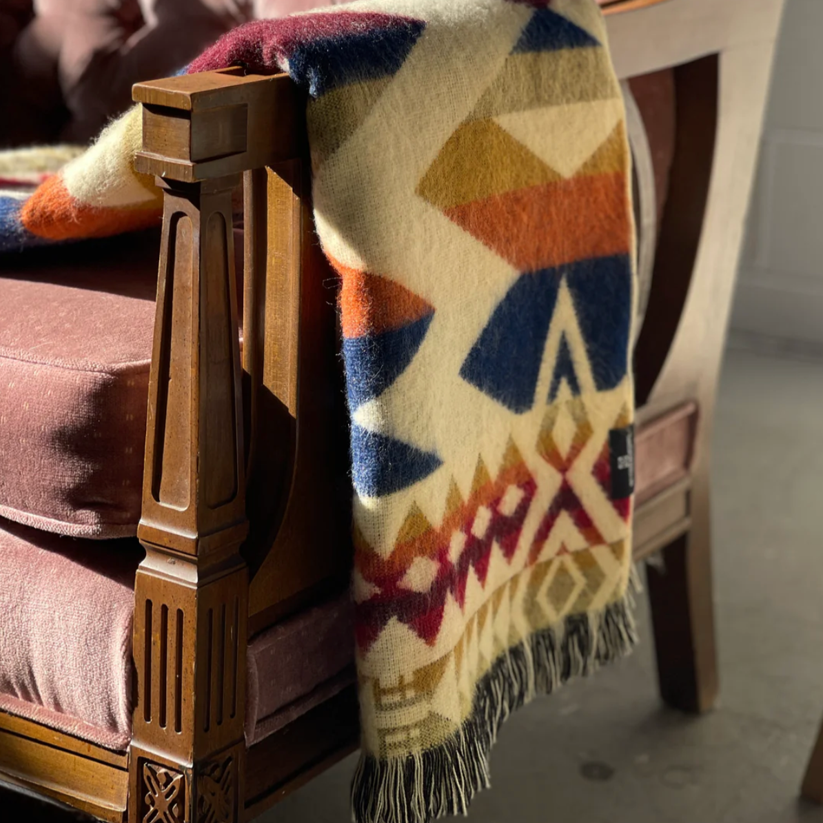 Colorful patterned blanket draped over a wooden chair