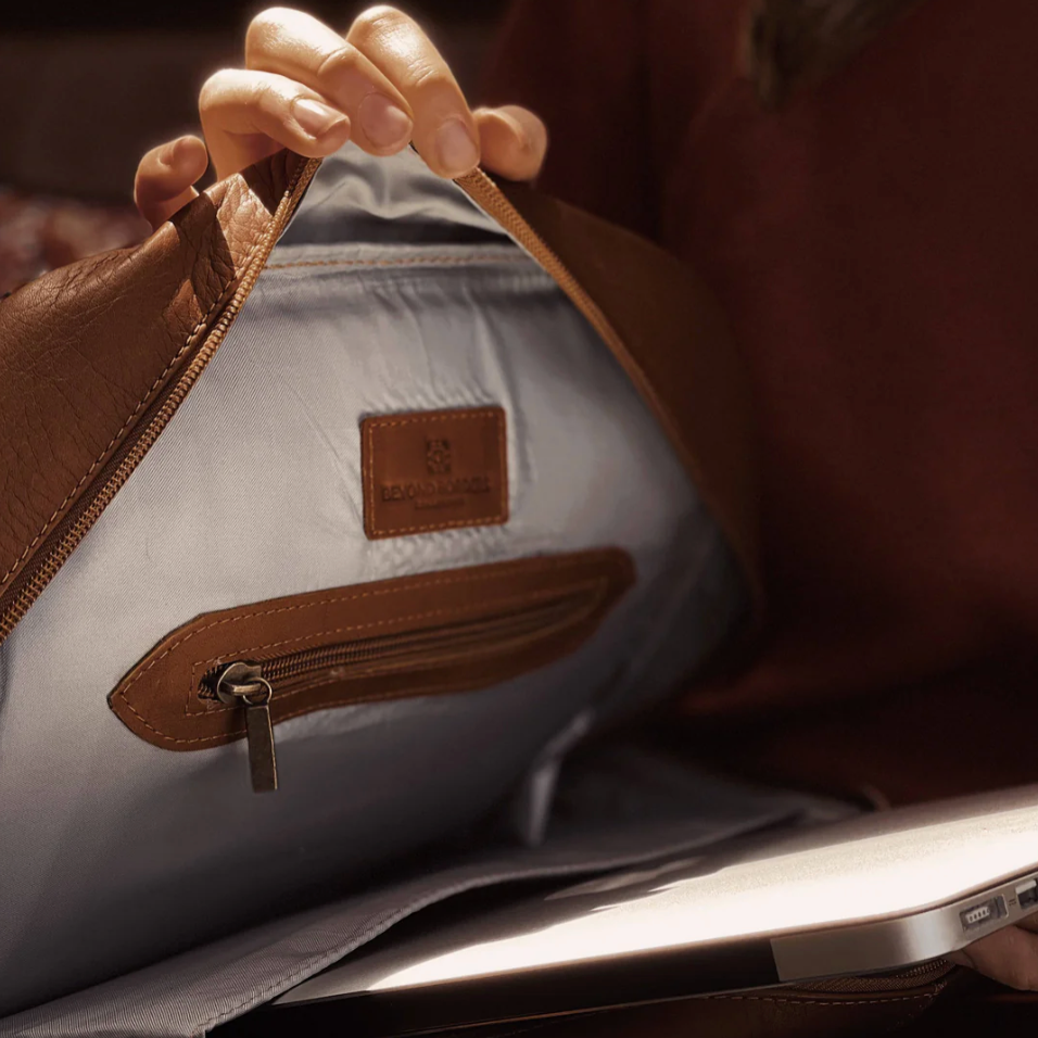Close-up of a person holding a gray bag with a visible brand logo.