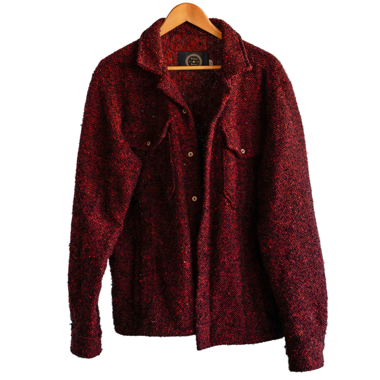 Red textured jacket on a hanger against a gray concrete wall