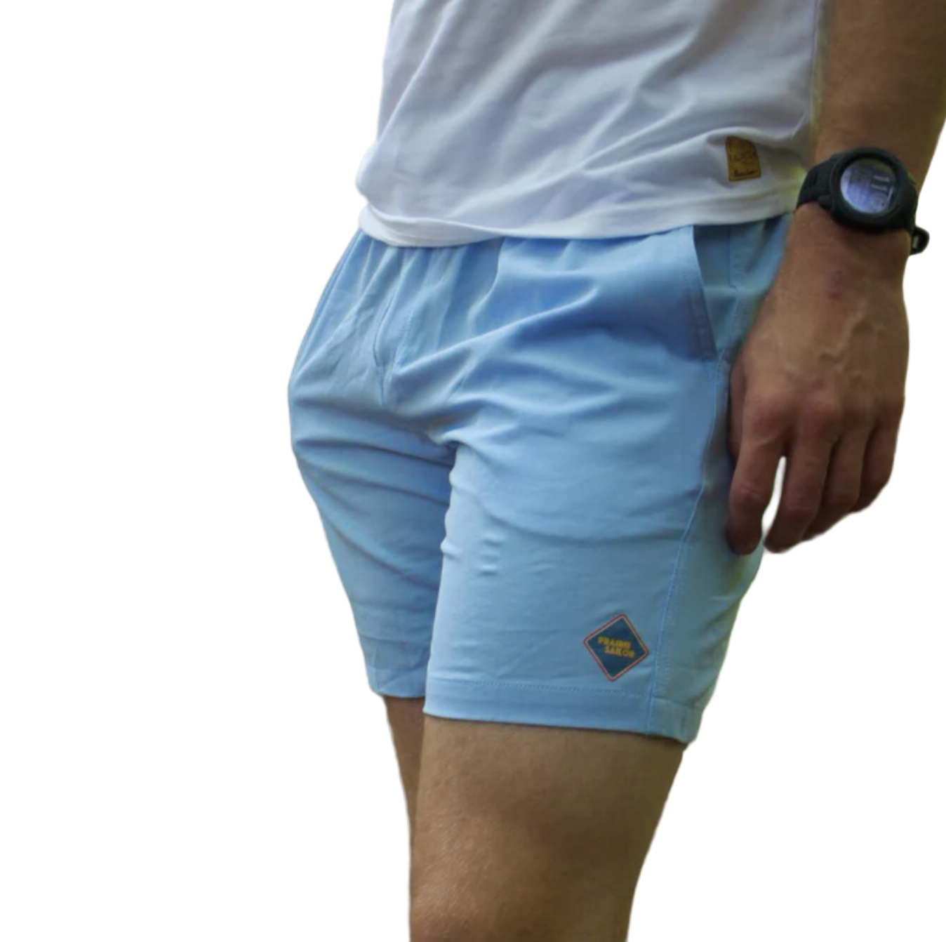Person wearing light blue shorts with a logo, white shirt, and black watch outdoors.