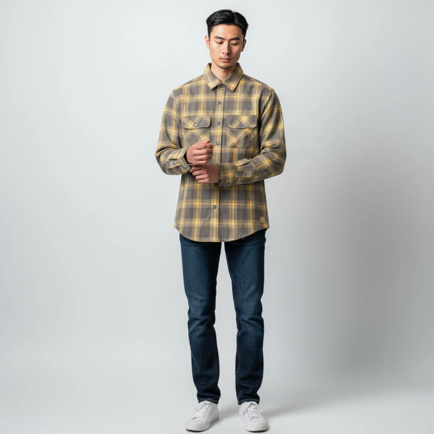 Man wearing a plaid shirt and jeans on a white background